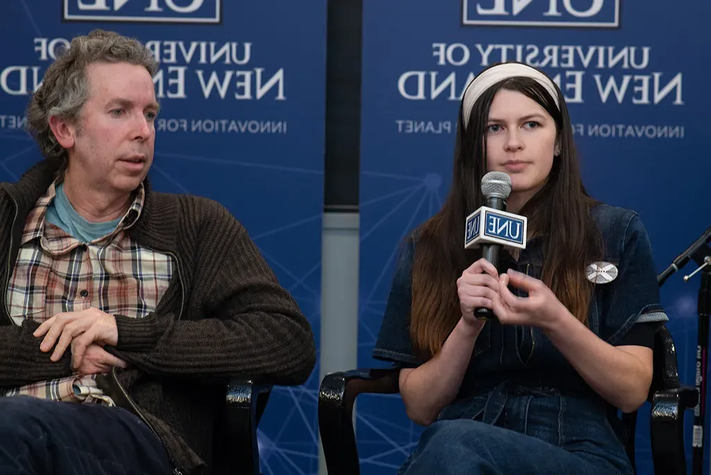 A U N E student asking a question on mic at an Environmental Council meeting